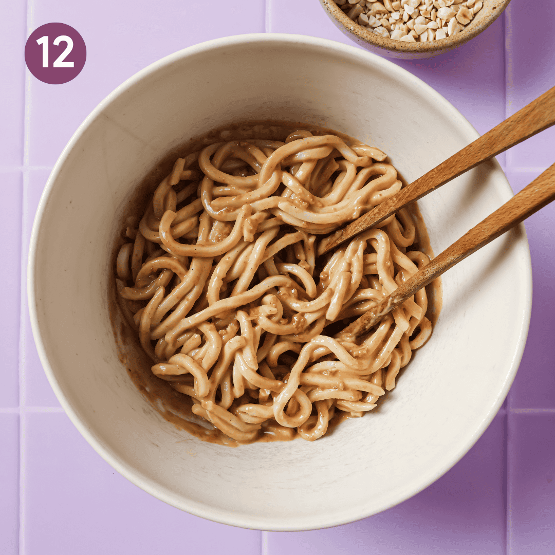 peanut sauce-coated udon noodles in the bowl.