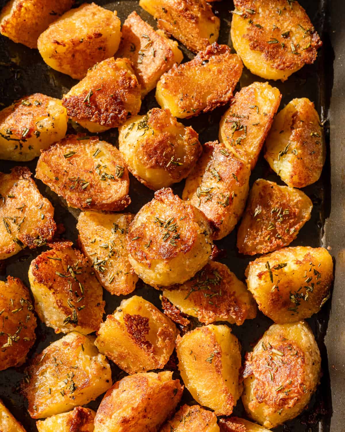Close up photo of crispy roasted potatoes on a pan.
